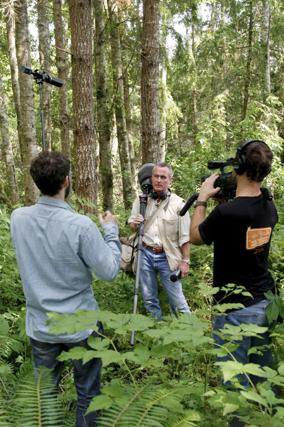 The crew filming Gordon among ferns and tall trees.